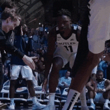 a basketball player wearing a butler 11 jersey
