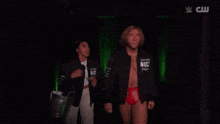 a man and a woman are standing next to each other in a dark room in front of a green wall .