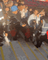 a group of people are standing on a set of stairs and one of them has a blue hat on