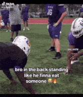 a group of football players are standing on a field . one of the players is wearing a number 16 jersey .