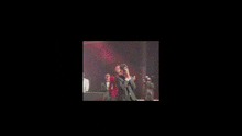 two men in tuxedos are dancing in a dark room .
