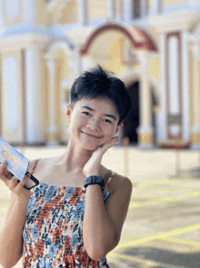 a woman in a floral dress is holding a box with a picture of a baby on it
