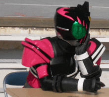 a person in a pink and black costume is sitting at a desk