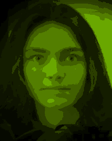 a woman 's face is shown in a green light