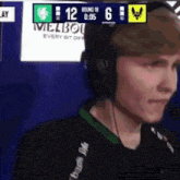 a man wearing headphones is talking into a microphone in front of a sign that says melbourne