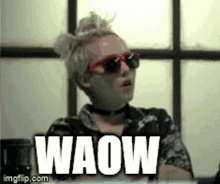 a woman wearing sunglasses and a choker has the word waow on her chest