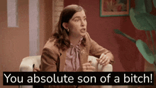 a woman is sitting in a chair with the words " you absolute son of a bitch " above her