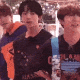 a group of young men are standing next to each other in a room and smiling .