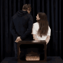 a man and a woman standing in front of a box with a bowl of food in it