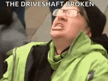 a woman wearing glasses and a green jacket is making a funny face and screaming .