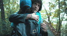a man in a blue hat is hugging another man in a black jacket