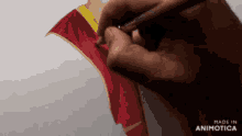 a person is drawing a red and yellow scarf with a brush and the words made in animotica are visible in the corner
