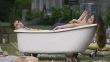 a man and a woman laying in a bathtub