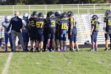 a group of football players huddled together with the number 3 on their back