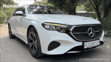 a white mercedes with a license plate that says dl12c0007tc