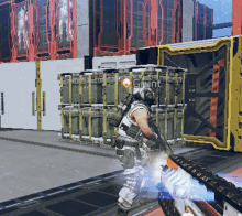 a man holding a gun in front of crates that say gruint