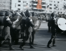 a group of soldiers marching down a street with a drummer in front of them