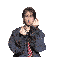 a woman in a suit and tie is making a heart with her hands
