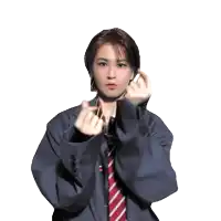 a woman in a suit and tie is making a heart with her hands