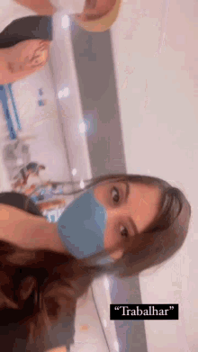 a woman wearing a blue mask is standing next to a man with the word trabalhar on the bottom