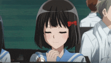 a girl with a red bow in her hair is sitting in a classroom