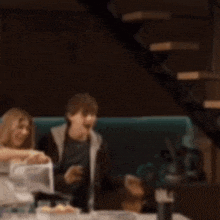 a blurry picture of people sitting at a table in a dark room