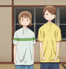a boy and a girl standing next to each other in front of a window