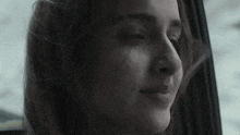 a close up of a woman 's face looking out of a car window