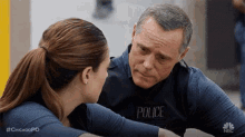 a man and a woman are looking at each other . the man is wearing a police uniform .