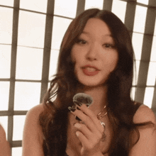 a woman is holding a brush in her hand and looking at the camera