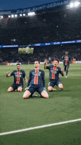 a group of soccer players are kneeling on the field in front of a crowd .