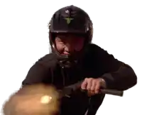 a man wearing a helmet is holding a gun in his right hand