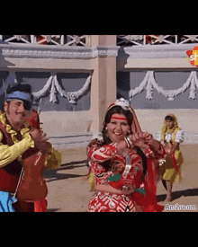 a group of people dancing in front of a building with anshu.com written on the bottom