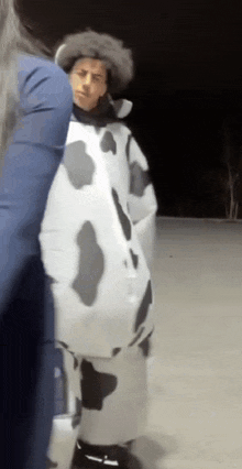 a man in a cow costume stands next to a woman