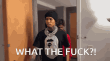 a man standing in a room with the words what the fuck written on the bottom