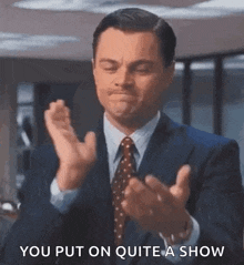 a man in a suit and tie is clapping his hands with the words `` you put on quite a show '' .