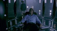 a man sits in a chair with his eyes closed and a keyboard in front of him