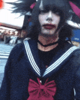a person with blood on their face wearing a sailor uniform