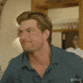 a man in a blue shirt with a netflix logo on the bottom right