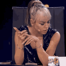 a woman sitting at a table with a box that says ps on it