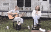 a man playing a guitar and a woman playing a flute
