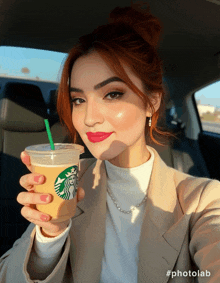 a woman in a car holding a starbucks drink with a green straw