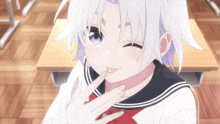 a girl with white hair is sitting at a desk with her hand on her face