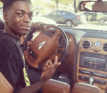 a young man is sitting in a bentley car
