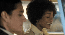 a man and a woman are sitting in a car with the woman smiling