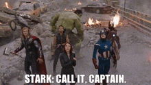 a group of avengers are standing next to each other in a city .