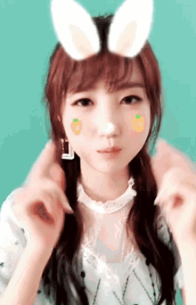 a girl with bunny ears on her head is making a face