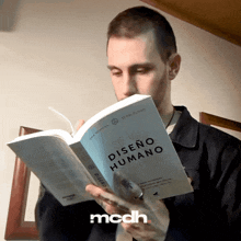 a man reading a book called diseño humano