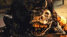 a person is holding a knife in front of a statue of a monster .