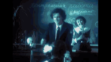 a man in a suit stands in front of a blackboard that says контрольная работа